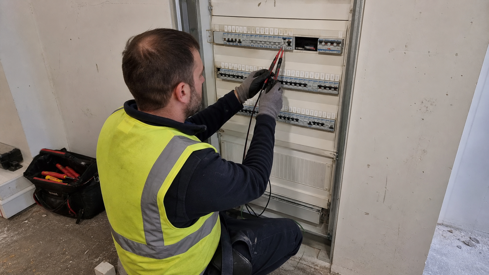 Technicien repérant les circuits d’un tableau électrique